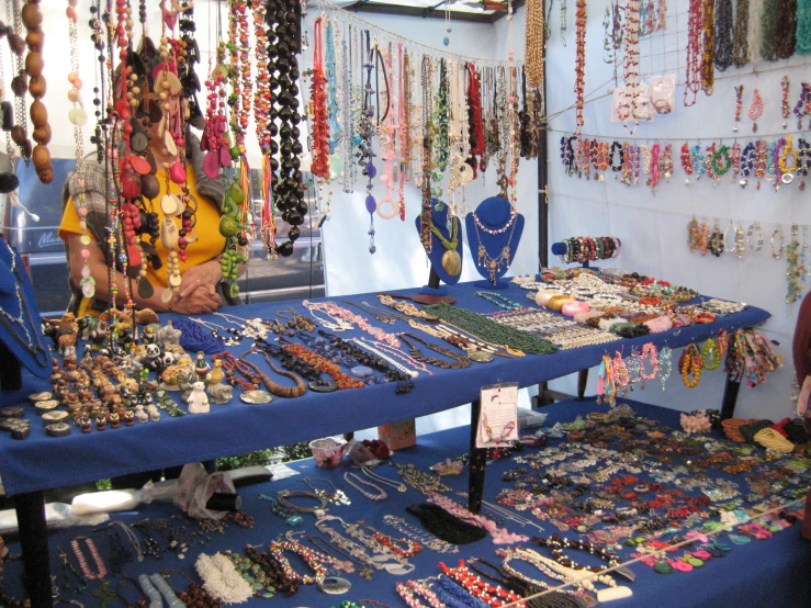 an outdoor market selling jewelry and necklaces