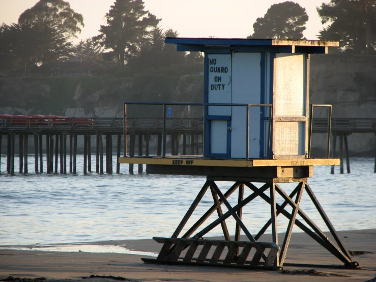 a dock on the beach with a light house