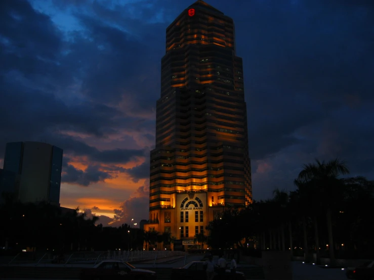 a large glass tower in the evening with red light from lights on