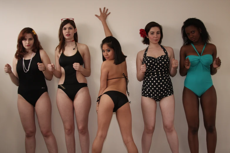 five bikini clad women posing for a picture