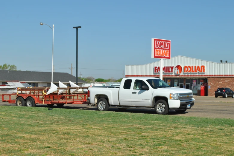 a white truck pulling a trailer filled with wooden logs