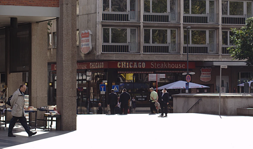 people walking past a row of stores on the corner