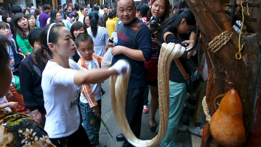 many people in a crowded area with guitars