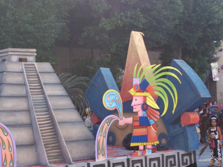 two children on parade float with many statues