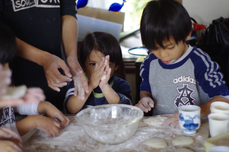 a couple of children that are standing near some food