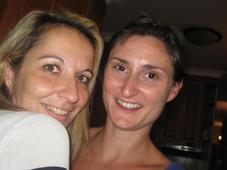 two women pose for a po in the kitchen