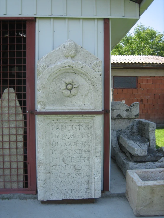 a grave marker near some rocks and a building