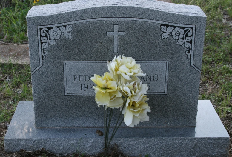 the head of a grave decorated with white flowers