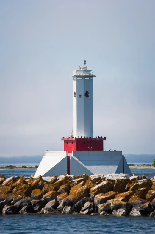 a lighthouse on the shore with the ocean in the background