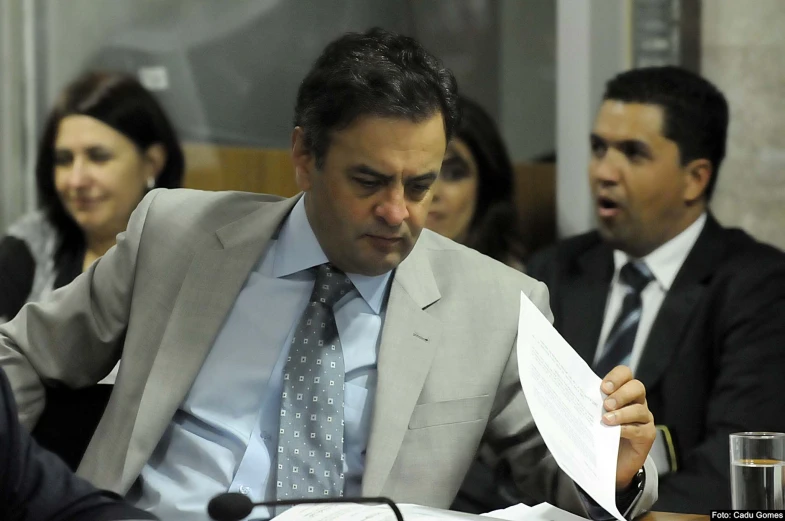 a man in a suit reading a piece of paper