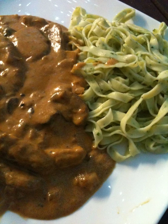 pasta and green noodles on a white plate