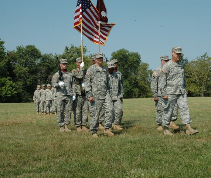 men in uniforms standing with american flags