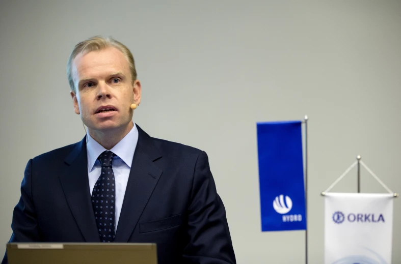 a man stands behind a podium wearing a suit and tie