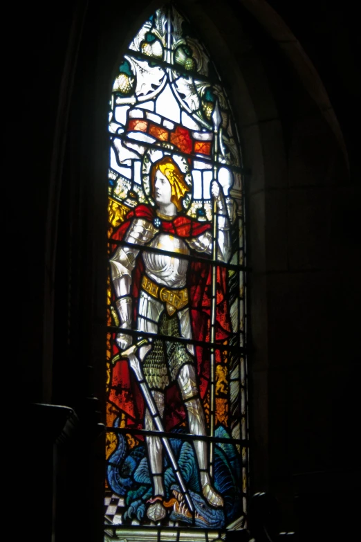 a stain glass window with a man holding a sword