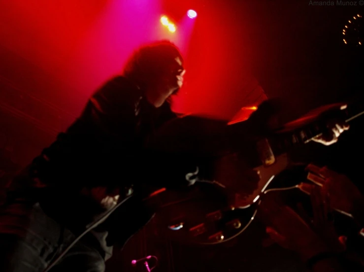 a person playing a guitar with red lights