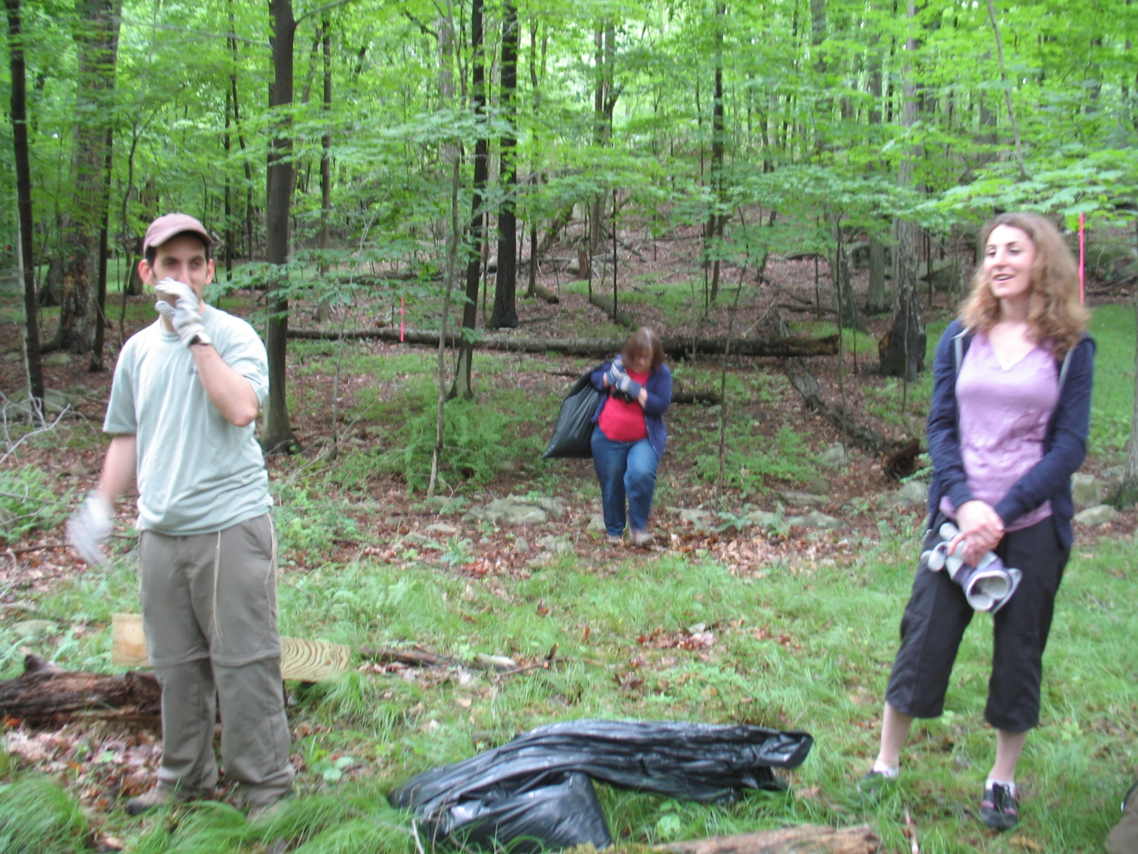 a group of people stand around in the woods