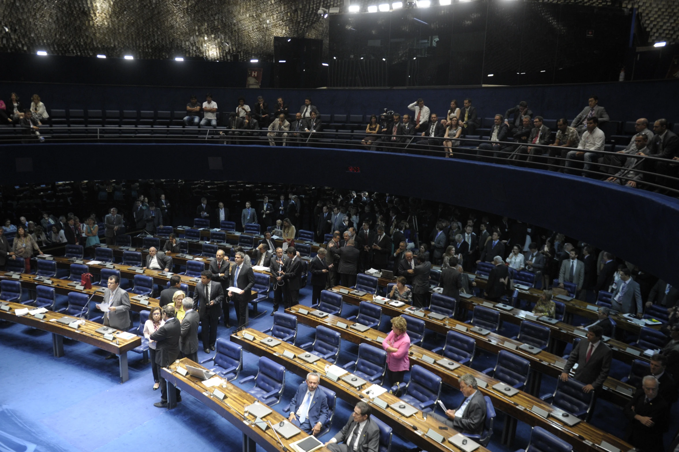 a crowded parliament room with people waiting to receive