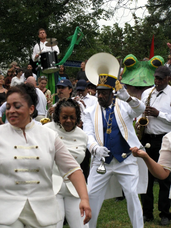 some people in white clothes some trees and some green and yellow flags