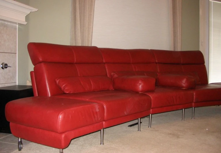 red couch with metal legs sitting in front of window