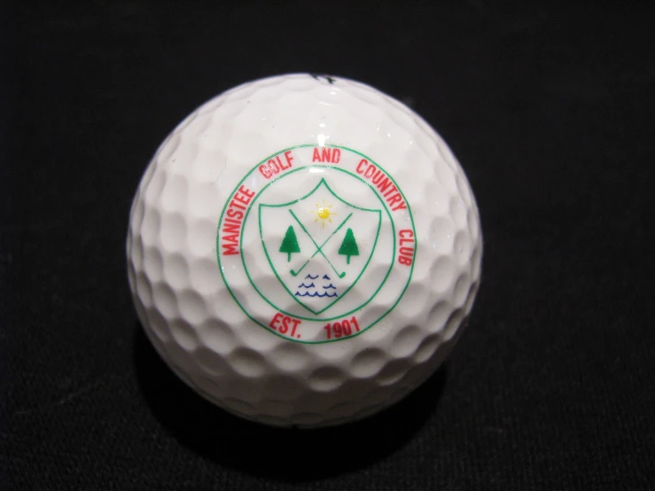 a golf ball with a green emblem on the front