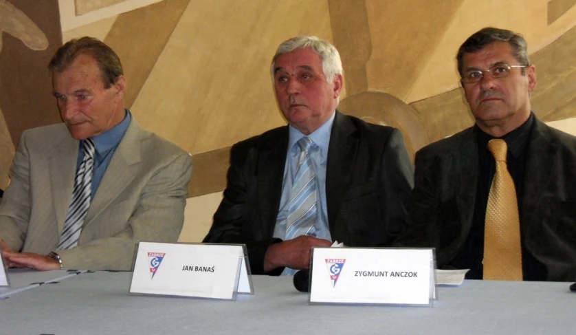 a group of men sitting at a table next to each other