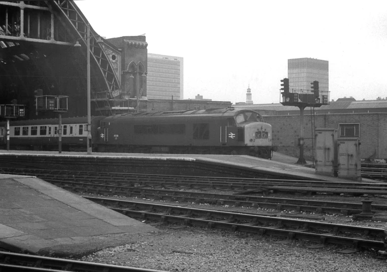 train passing through the station on tracks near buildings