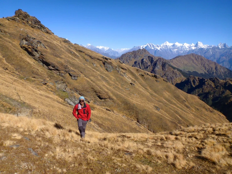 a man is walking on the side of a mountain