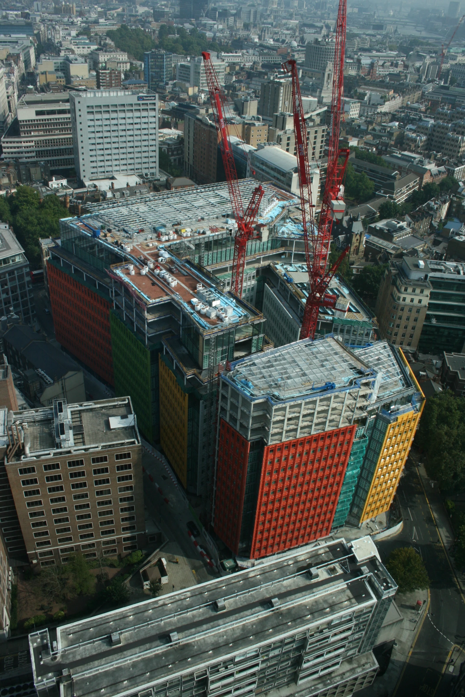 two cranes near buildings and large buildings in the city