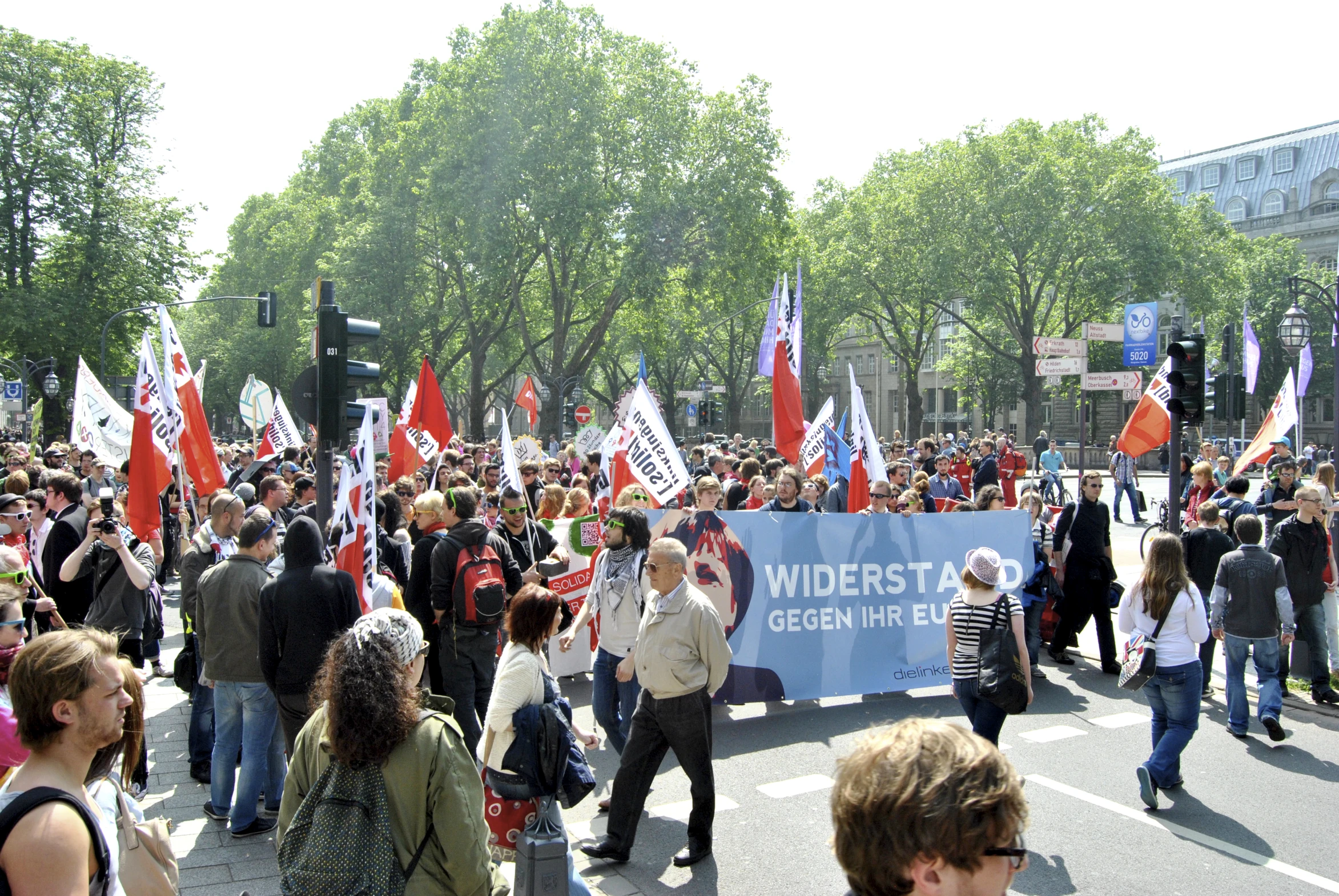 the people are standing near a group of flags