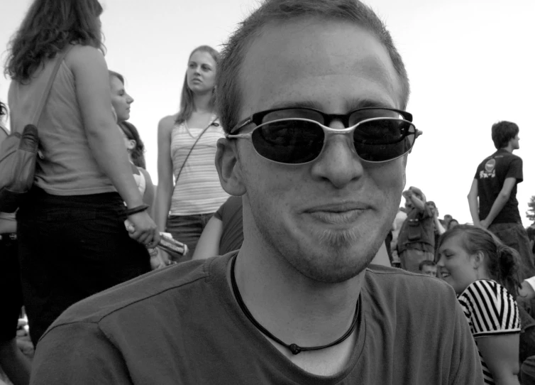 black and white pograph of man wearing sunglasses at beach