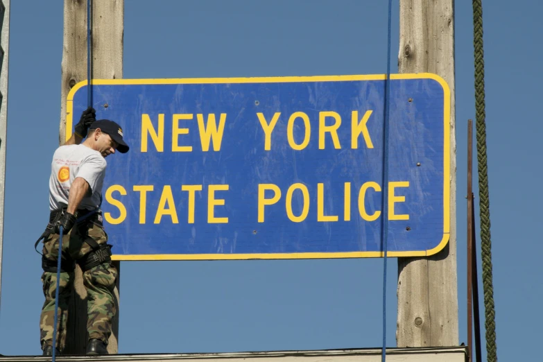 a police officer standing next to the blue sign