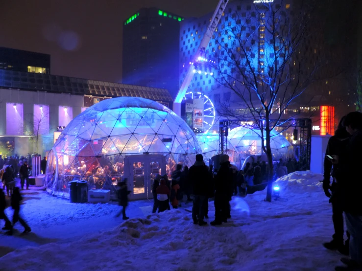 a group of people gathered around ice domes