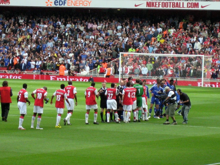 soccer players and spectators are gathered on the field