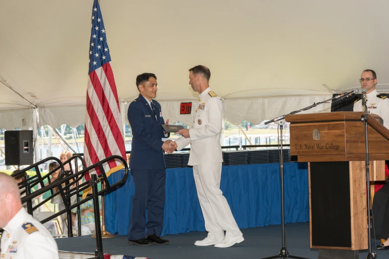 two men are dressed in white on a stage