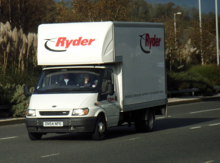 a white truck driving down a city street