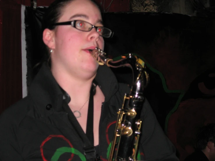 a woman in glasses playing a saxophone