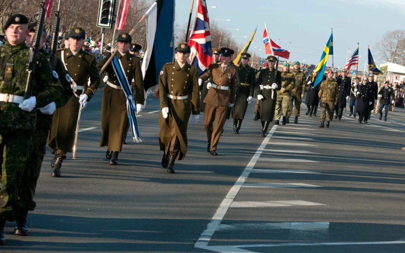 a group of men and women in military uniforms walking on a road