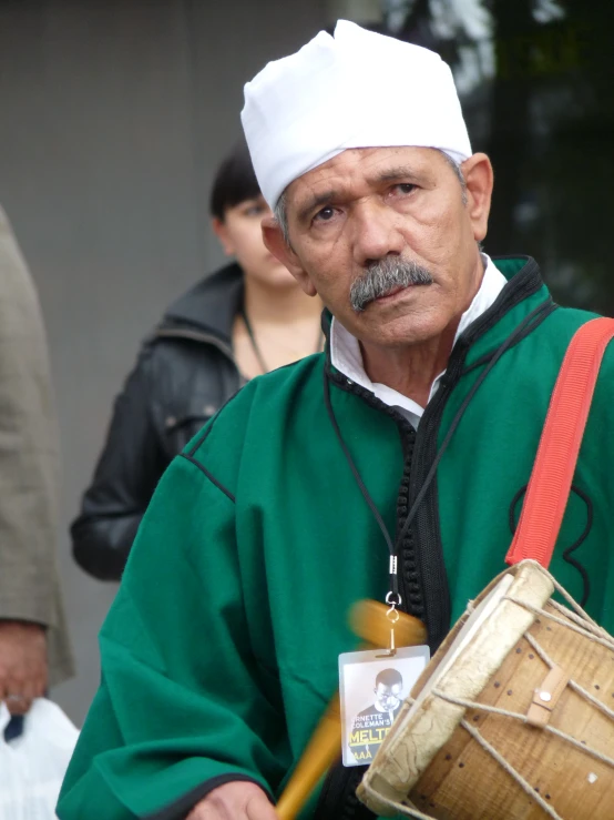 a man with a white hat and a drum