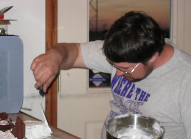 a man standing at a counter  a cake