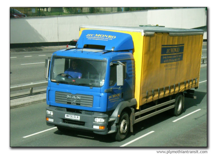a large blue truck is driving down the road