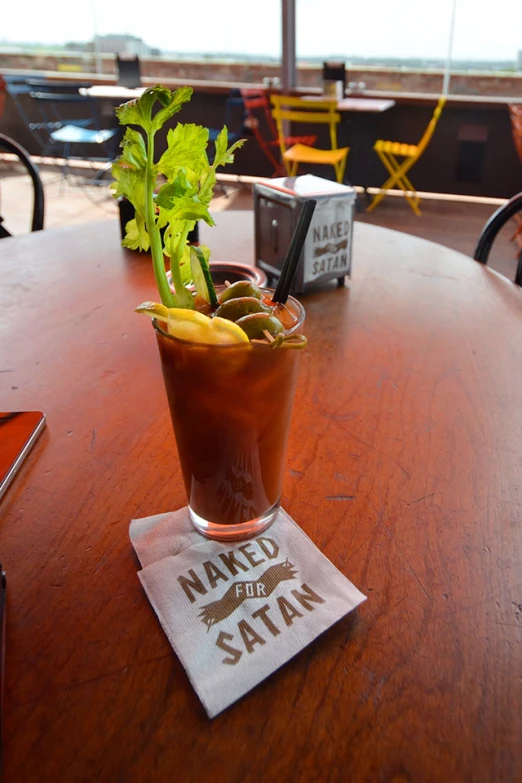 an iced drink with fruit on top sits on a restaurant table