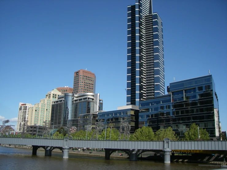 a bridge over a body of water leading into some tall buildings
