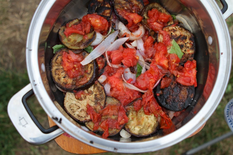 food is cooking in a stainless steel pot on a table