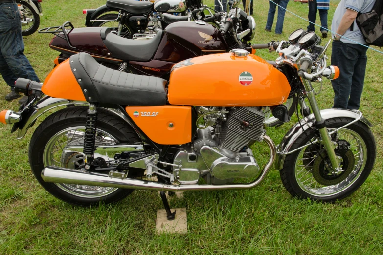 an orange motorcycle is parked on the grass