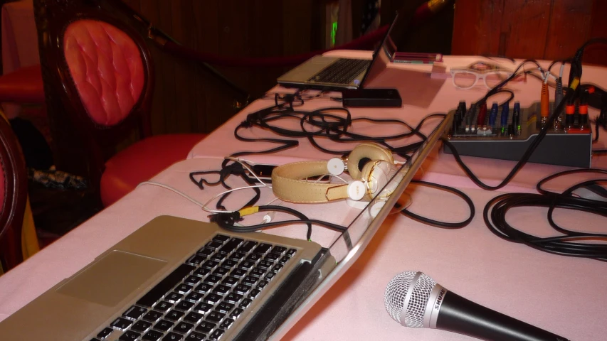 there is a microphone, an electronic device and other electronic equipment on the table