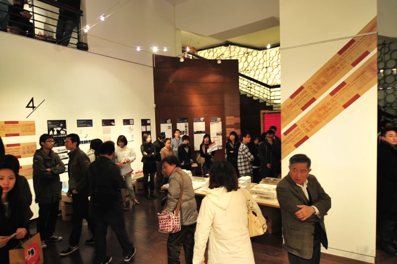 a group of people in an event looking at posters