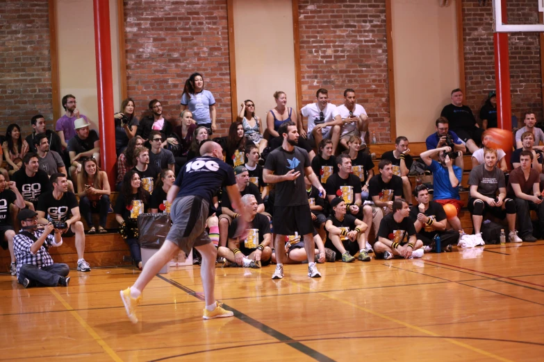 people on a court playing basketball with many spectators in the background