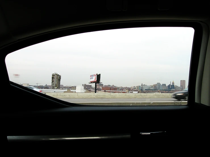 the view from a vehicle shows a highway on the other side of the city