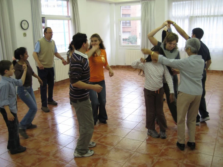 a group of young people are dancing in an apartment