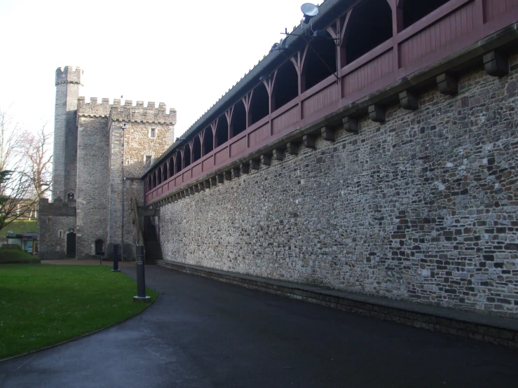 a castle like structure is behind a wall with brick lined walls